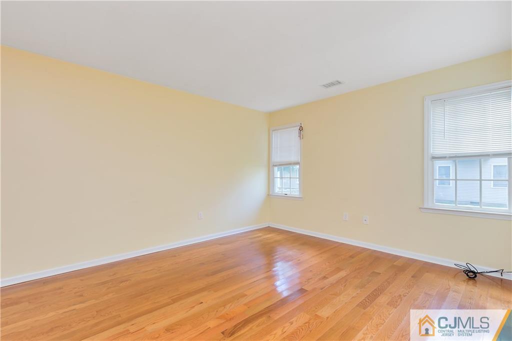 810 Edpas Road, Unit 810 New Brunswick, NJ 08901 - Photo 3 of 15 a view of an empty room with wooden floor and a window