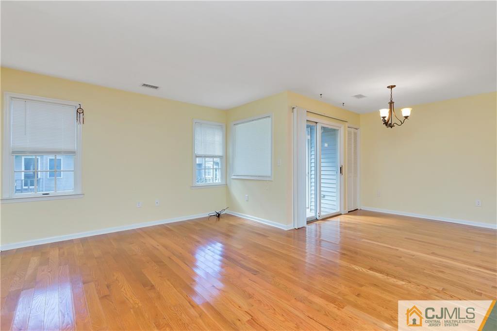 810 Edpas Road, Unit 810 New Brunswick, NJ 08901 - Photo 5 of 15 a view of an empty room with wooden floor and a window