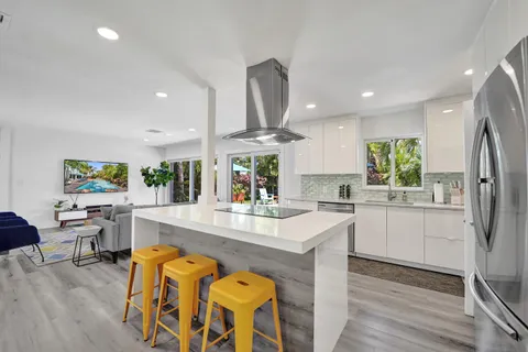 a kitchen with stainless steel appliances granite countertop a stove refrigerator and dining table