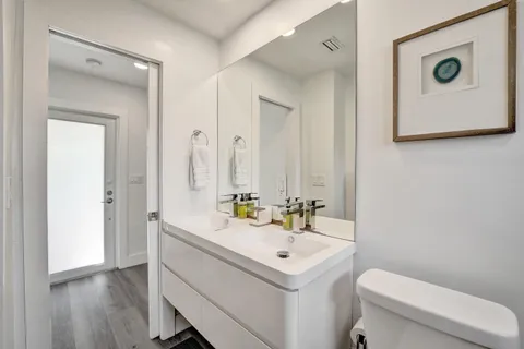 a bathroom with a sink a toilet and mirror