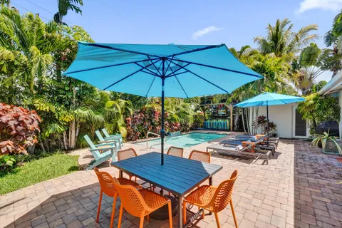 a view of patio with chairs and table under an umbrella
