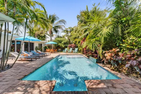 a view of a house with swimming pool and sitting area