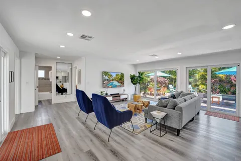 a living room with furniture and a wooden floor