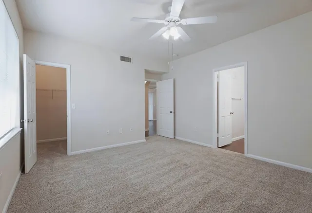 an empty room with a ceiling fan and a fan