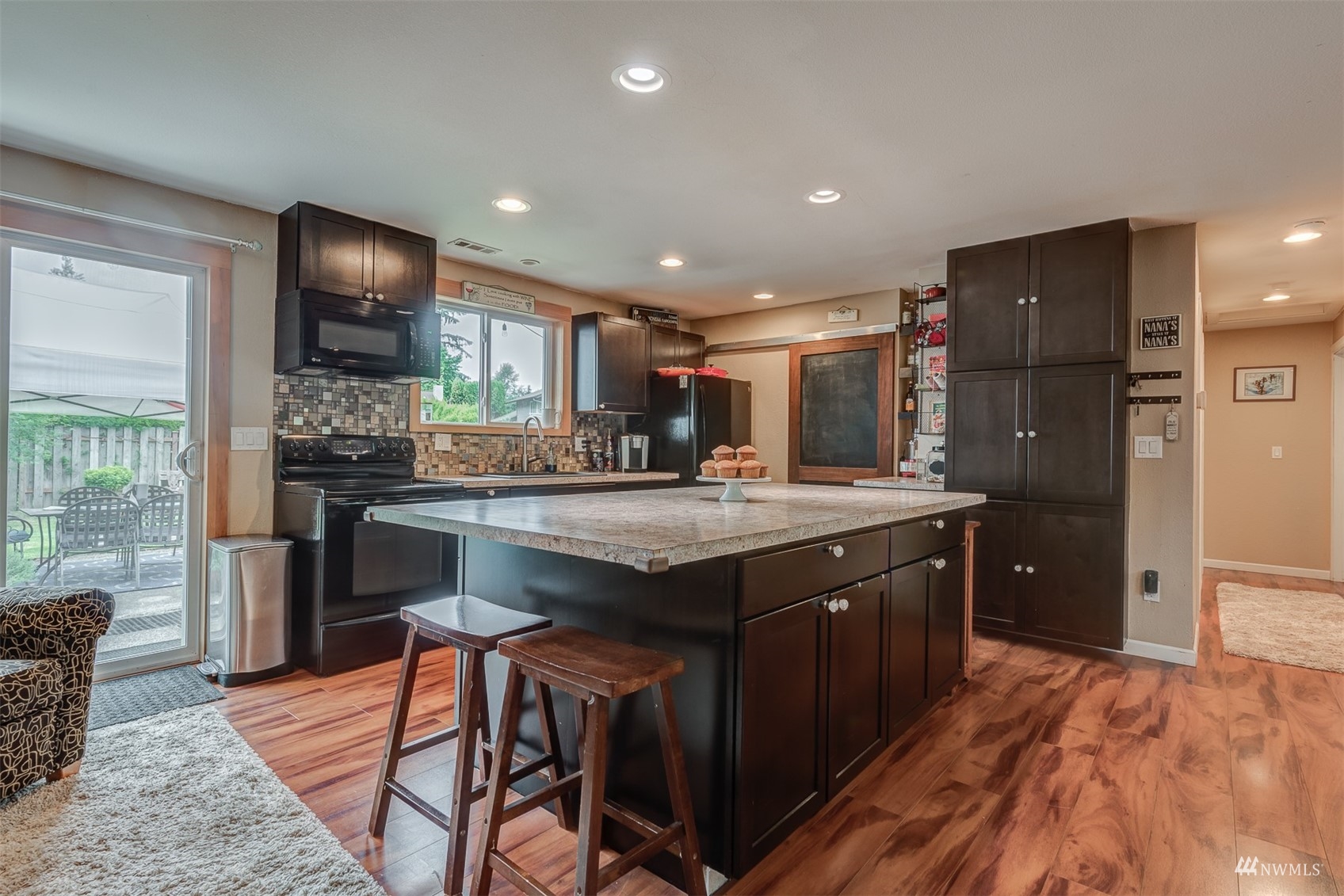 1825 225th Street Southeast Bothell, WA 98021 - Photo 9 of 30 a kitchen with stainless steel appliances granite countertop wooden cabinets a sink a stove a dining table and chairs