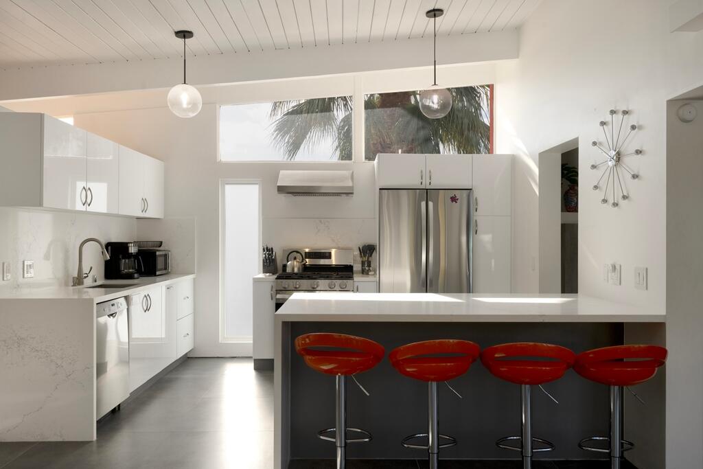 302 East Racquet Club Road Palm Springs, CA 92262 - Photo 12 of 38 a kitchen with stainless steel appliances granite countertop a stove a sink and a refrigerator with wooden floor