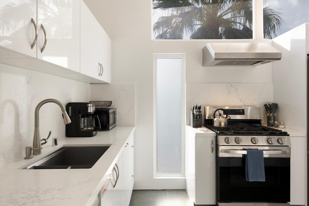 302 East Racquet Club Road Palm Springs, CA 92262 - Photo 13 of 38 a kitchen with a sink and a stove top oven