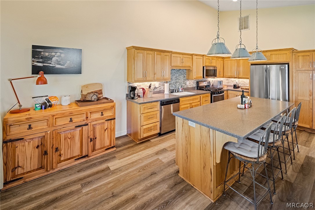 435 Wagon Wheel Road Big Bear City, CA 92314 - Photo 18 of 50 a kitchen with stainless steel appliances a stove a sink dishwasher and cabinets with wooden floor