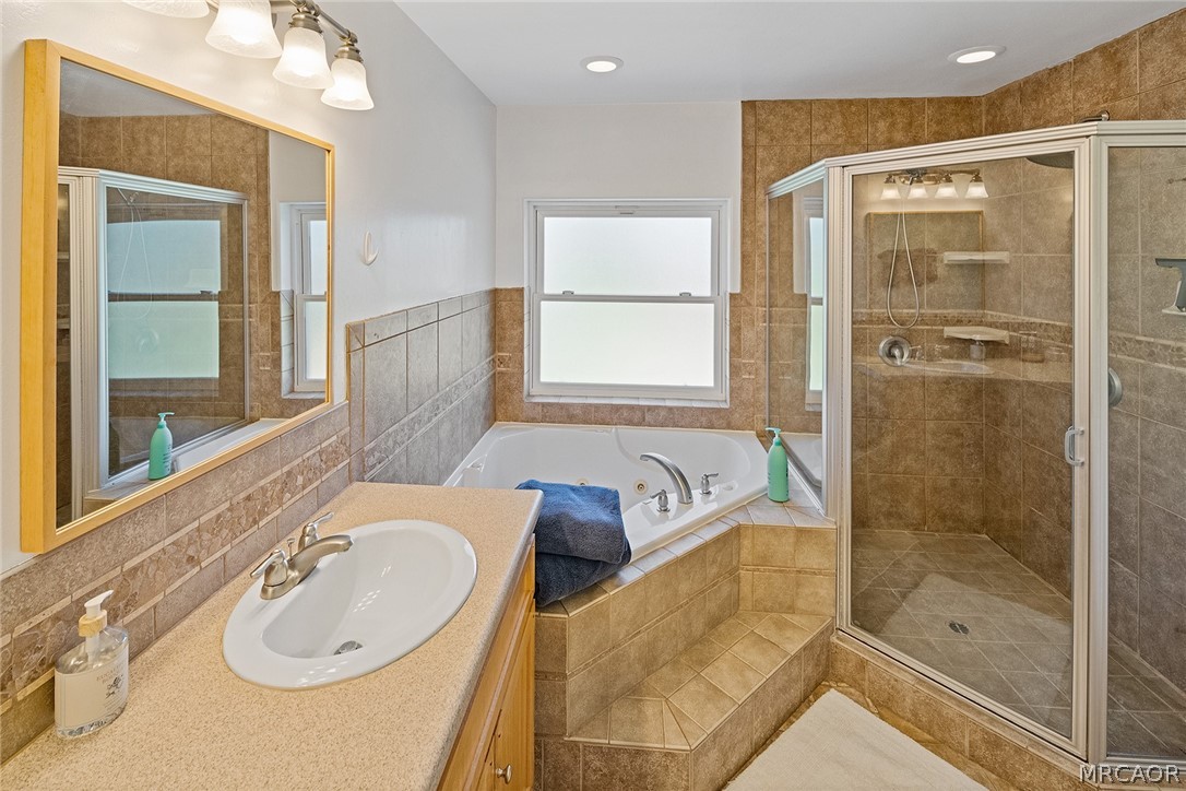 435 Wagon Wheel Road Big Bear City, CA 92314 - Photo 30 of 50 a bathroom with a granite countertop tub sink and mirror