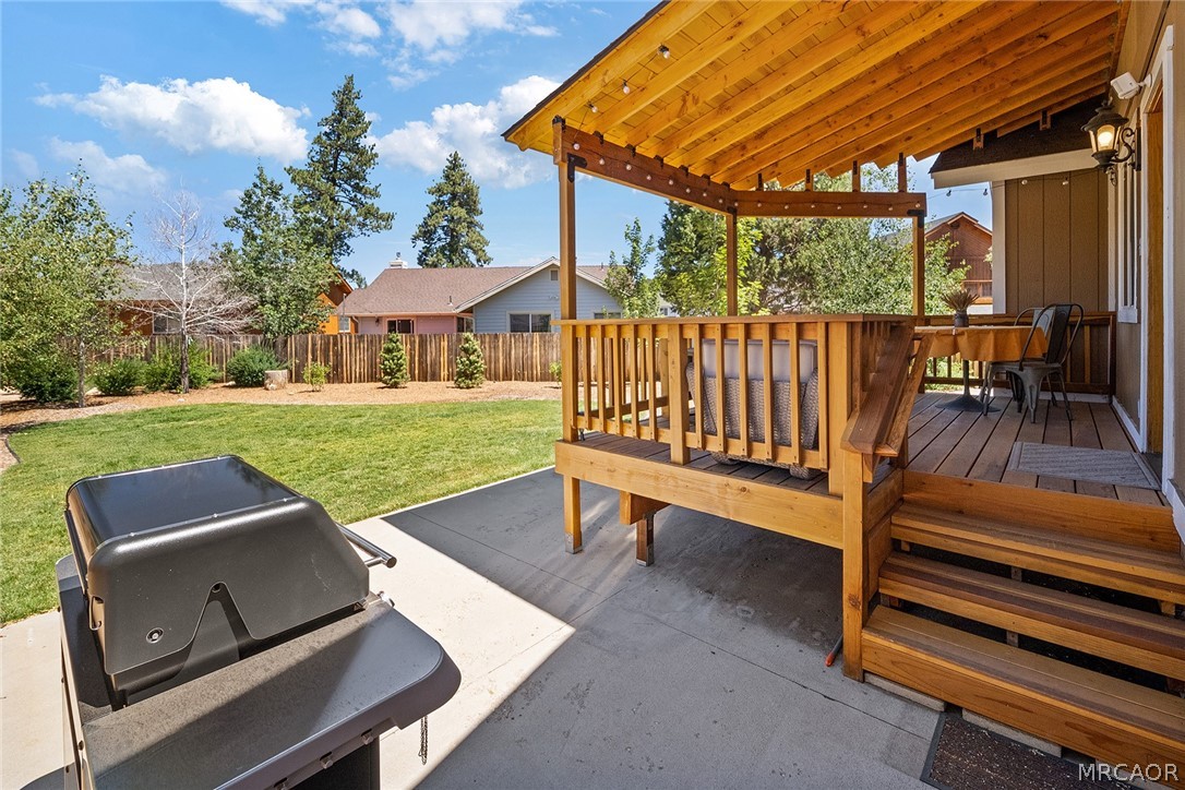 435 Wagon Wheel Road Big Bear City, CA 92314 - Photo 41 of 50 a view of a patio with table and chairs with wooden floor and fence