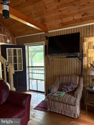 a living room with furniture a flat screen tv and a window