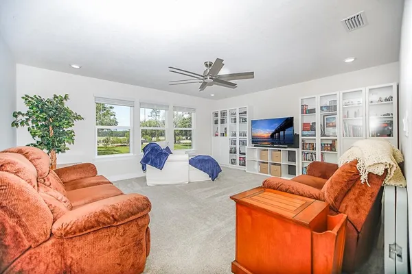 a living room with furniture a ceiling fan and a window