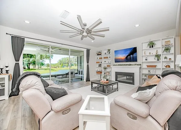 a living room with furniture a fireplace and a large window