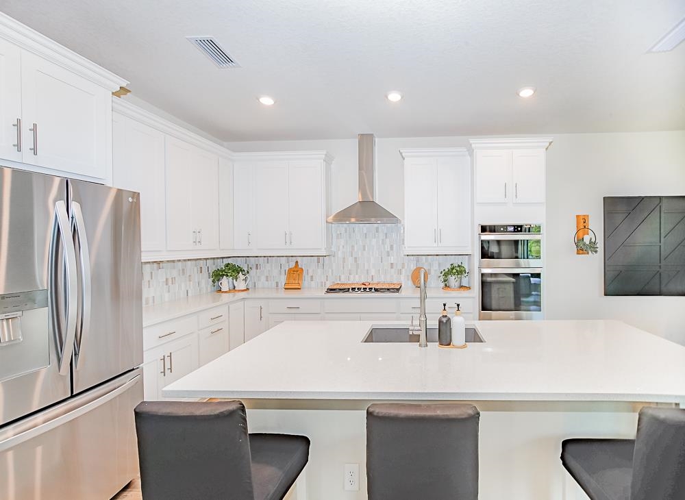 233 Red Barn Road St. Augustine, FL 32092 - Photo 28 of 40 a kitchen with kitchen island a refrigerator sink stove and cabinets