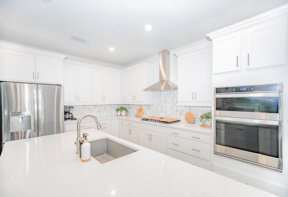 233 Red Barn Road St. Augustine, FL 32092 - Photo 29 of 40 a kitchen with granite countertop a sink stainless steel appliances and cabinets