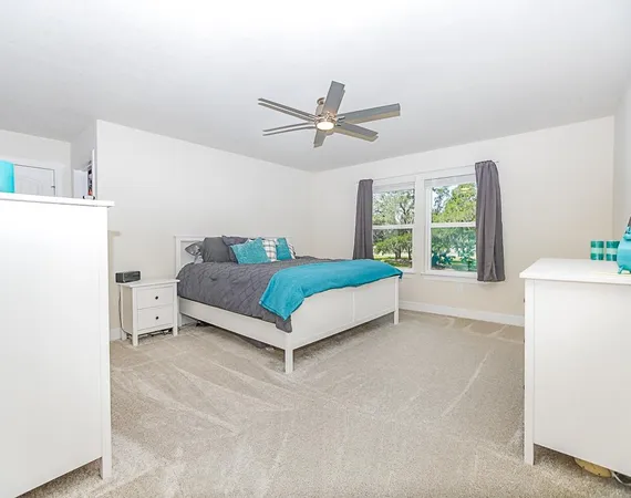 a living room with a bed furniture and a large window