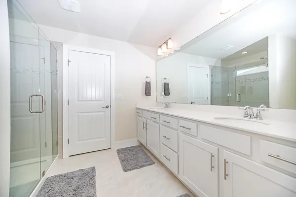 a spacious bathroom with double sink and a mirror