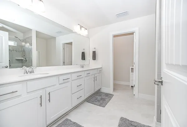 a spacious bathroom with double sink and a mirror