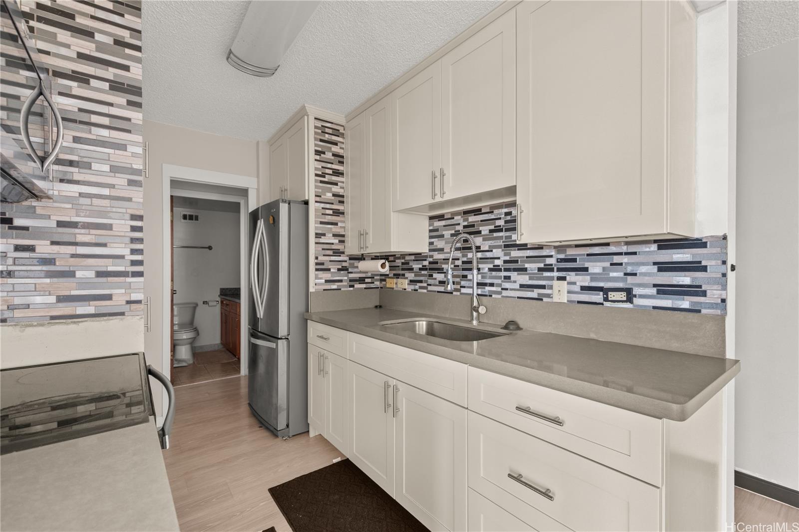 1069 Spencer Street, Unit 101 Honolulu, HI 96822 - Photo 2 of 19 a kitchen with a sink and refrigerator