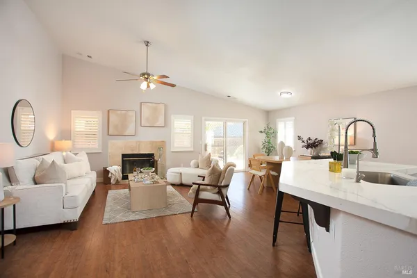 a living room with couches a fireplace and a chandelier