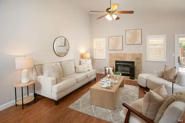 a living room with furniture a wooden floor and a lamp
