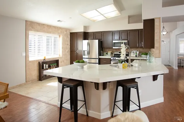 a kitchen with granite countertop a refrigerator and a stove top oven