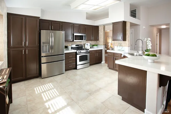 a kitchen with stainless steel appliances granite countertop a sink and a stove