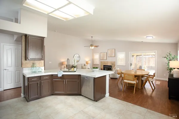 a kitchen with stainless steel appliances kitchen island granite countertop a refrigerator a stove a sink dishwasher and a oven with cabinets