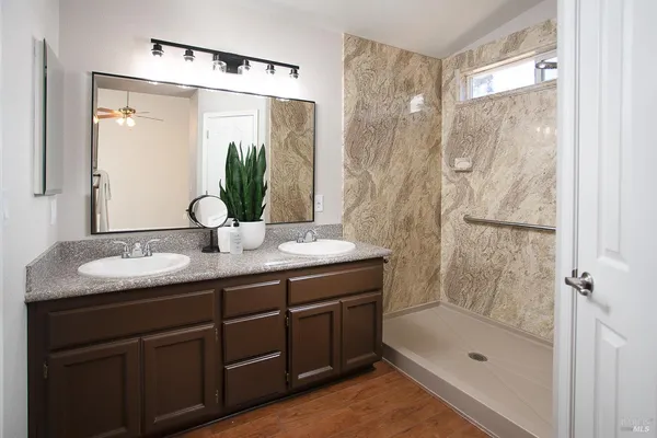 a bathroom with a granite countertop shower sink and mirror