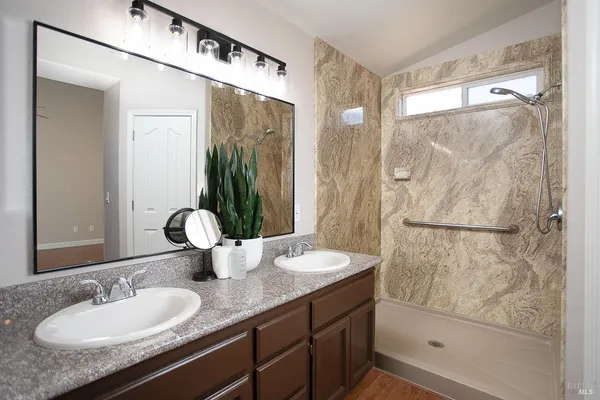 a bathroom with a granite countertop sink and a mirror