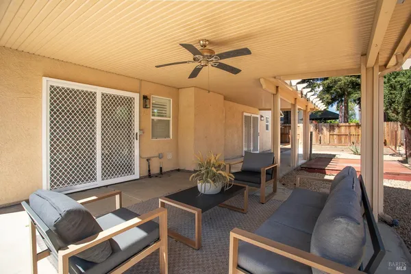 a view of a patio with couches and a table and chairs with wooden floor