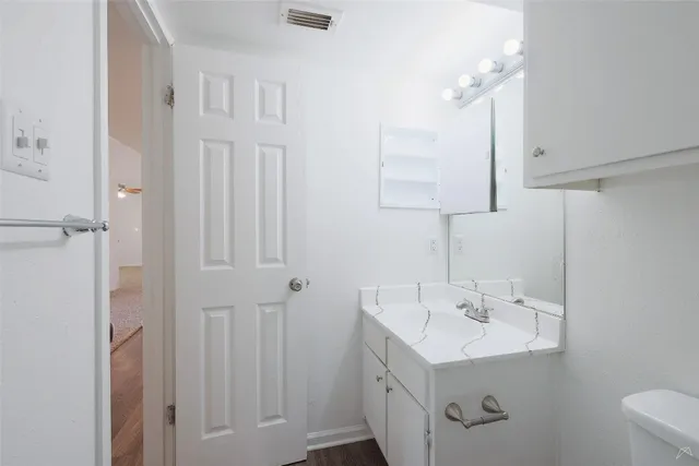 a bathroom with a sink a light fixture and a toilet