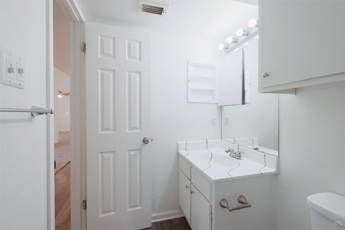 2323 Wells Branch Parkway, Unit A205 Austin, TX 78728 - Photo 15 of 22 a bathroom with a sink a light fixture and a toilet