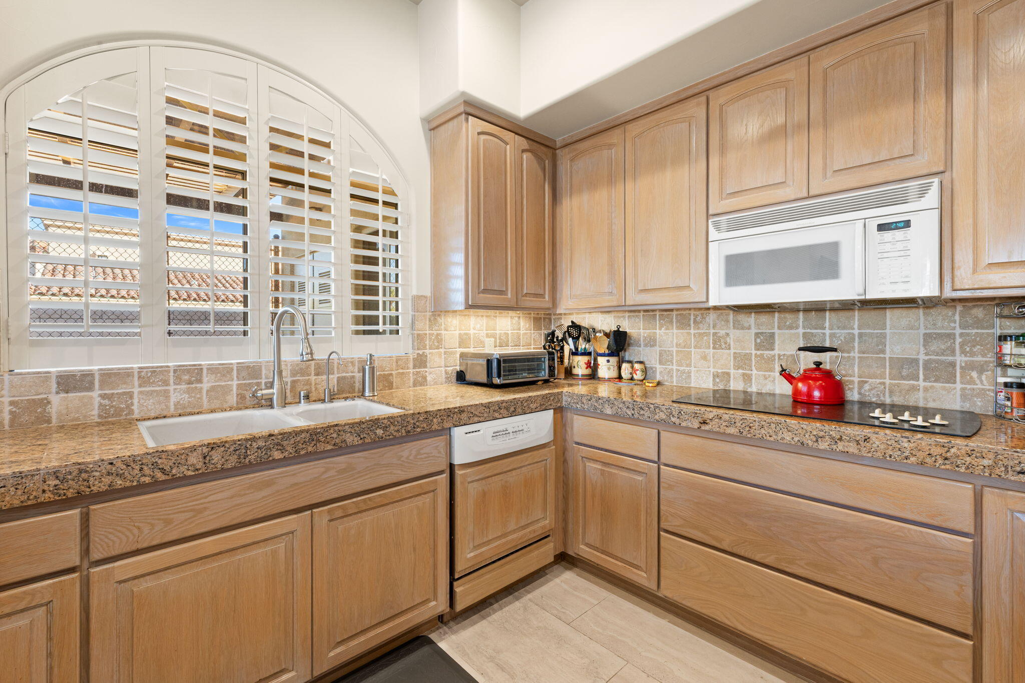 73110 Calliandra Street Palm Desert, CA 92260 - Photo 19 of 67 a kitchen with granite countertop white cabinets and white appliances