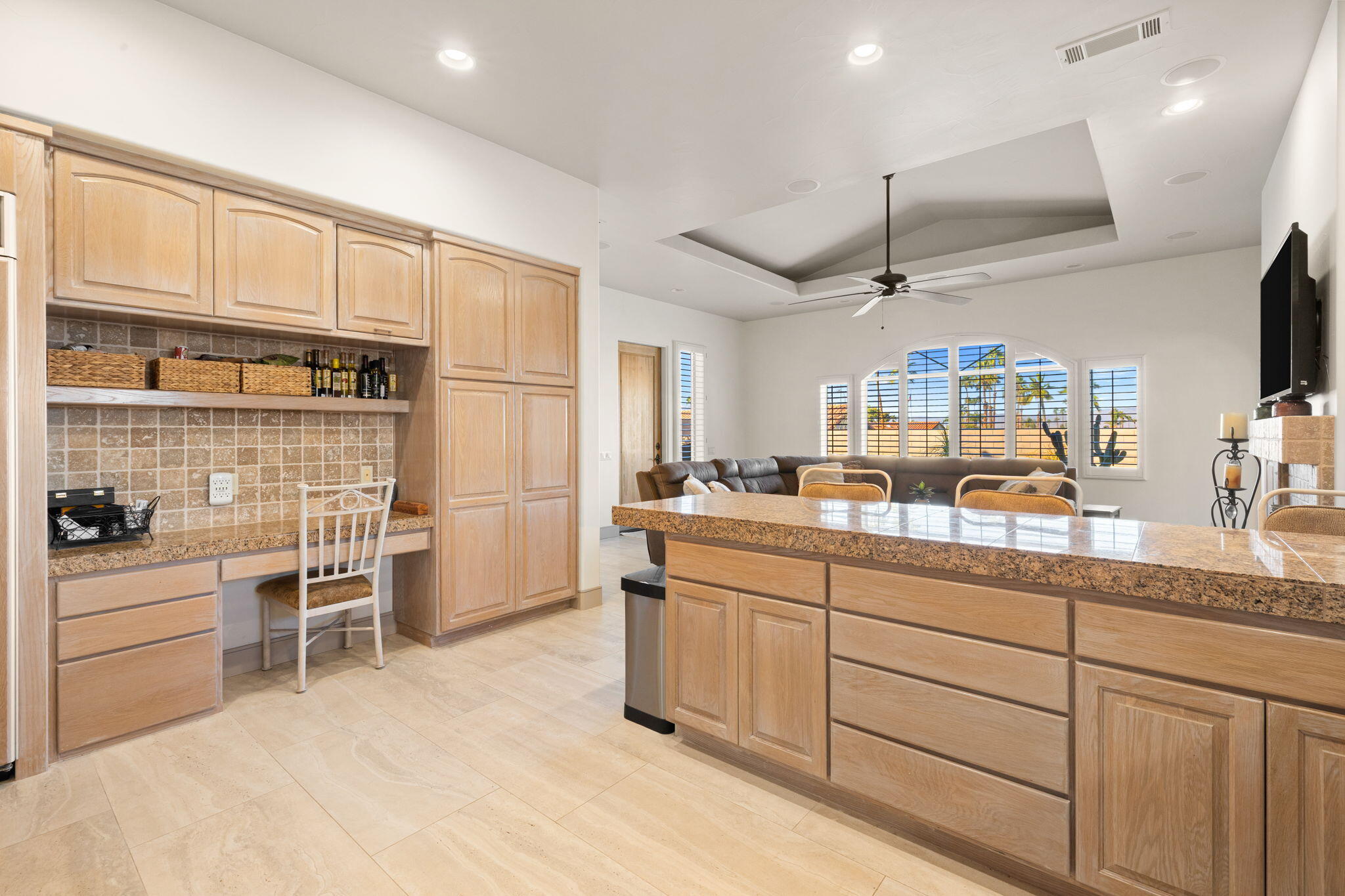 73110 Calliandra Street Palm Desert, CA 92260 - Photo 21 of 67 a kitchen with stainless steel appliances kitchen island granite countertop a stove top oven a sink a dining table and chairs with white cabinets