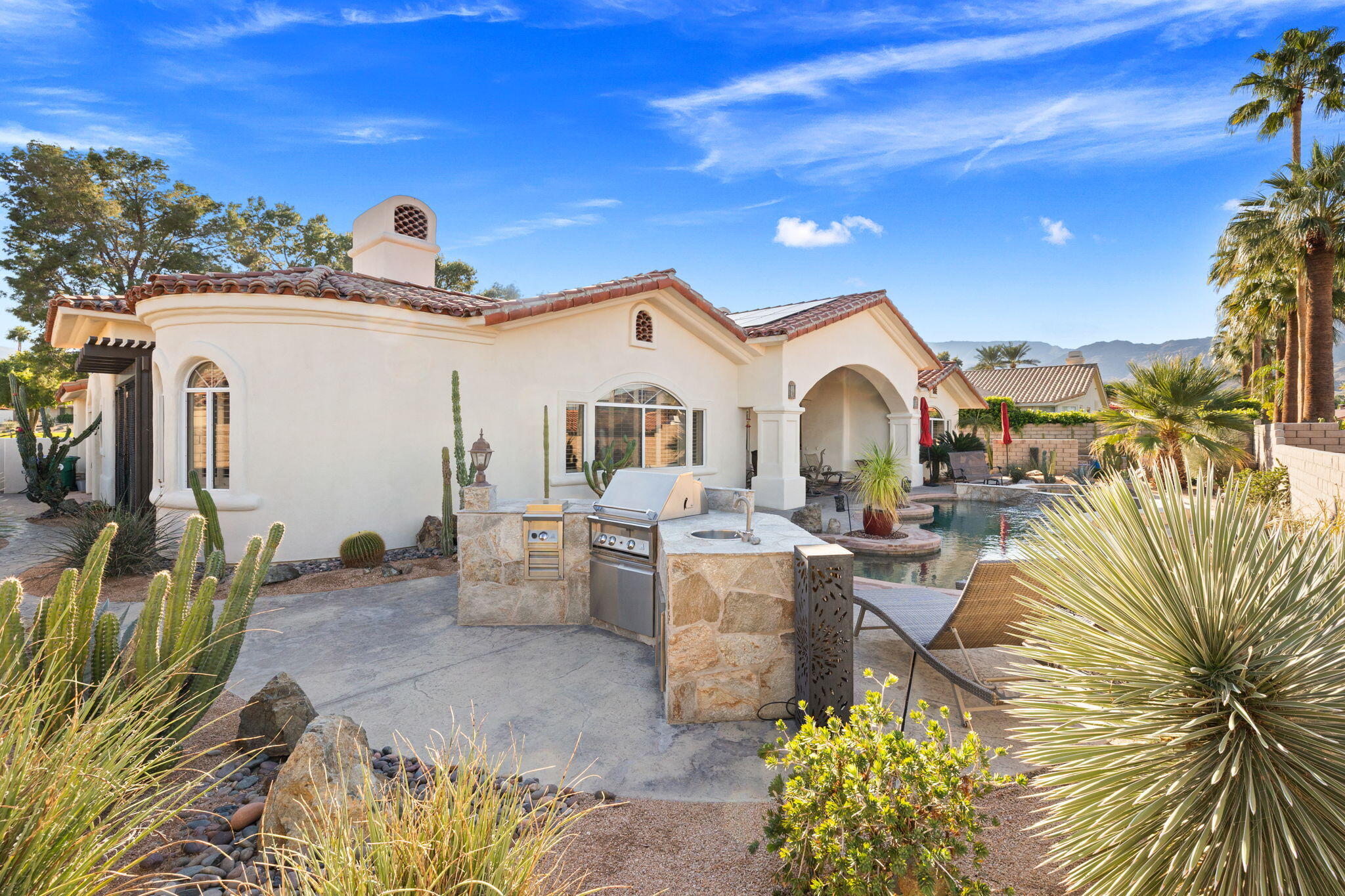 73110 Calliandra Street Palm Desert, CA 92260 - Photo 52 of 67 a view of a patio with couches under an umbrella next to yard