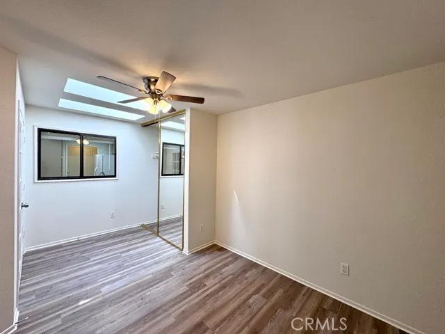 a view of a room with wooden floor and a ceiling fan