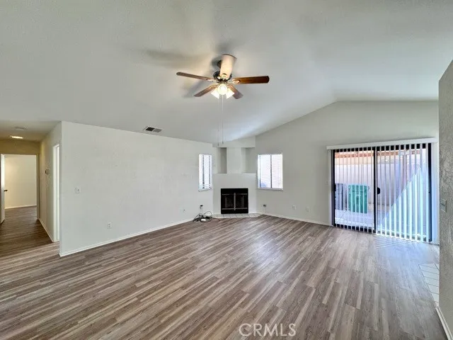 a view of a livingroom with wooden floor and a ceiling fan