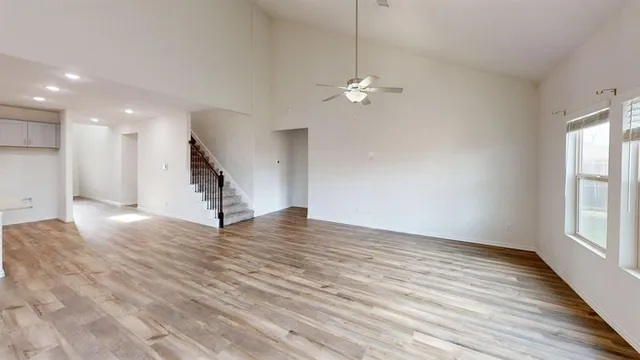 a view of empty room with wooden floor and window
