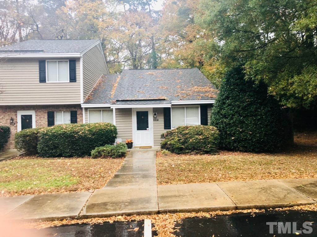 2100 Spring Forest Road, Unit 2100 Raleigh, NC 27615 - Photo 2 of 5 a front view of a house with a yard covered with trees