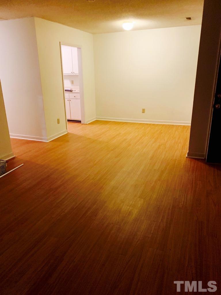 2100 Spring Forest Road, Unit 2100 Raleigh, NC 27615 - Photo 3 of 5 an empty room with a wooden door