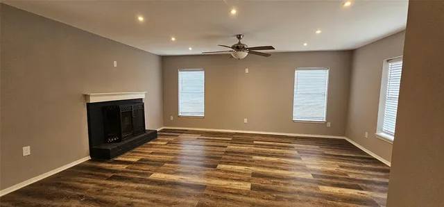 an empty room with windows and a fireplace