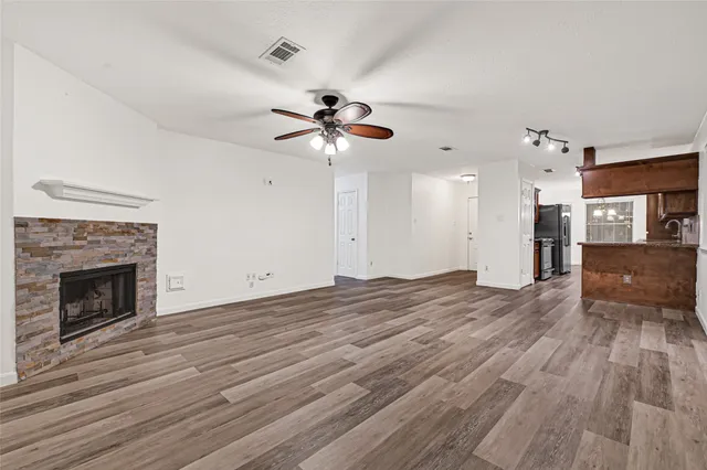 a view of empty room with wooden floor and fireplace
