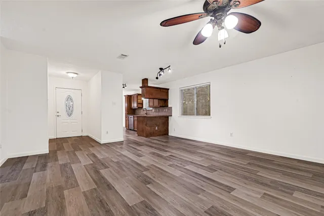 a view of empty room with wooden floor