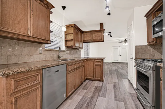 a kitchen with stainless steel appliances granite countertop a stove and cabinets