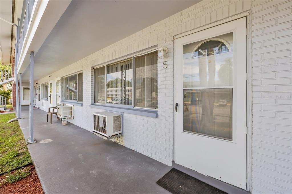 2353 Shelley Street, Unit 5 Clearwater, FL 33765 - Photo 1 of 21 a hallway with a bench and windows