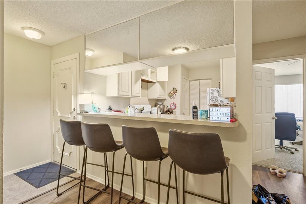 806 West 24th Street, Unit 228 Austin, TX 78705 - Photo 3 of 6 a kitchen with a dining table chairs sink and cabinets