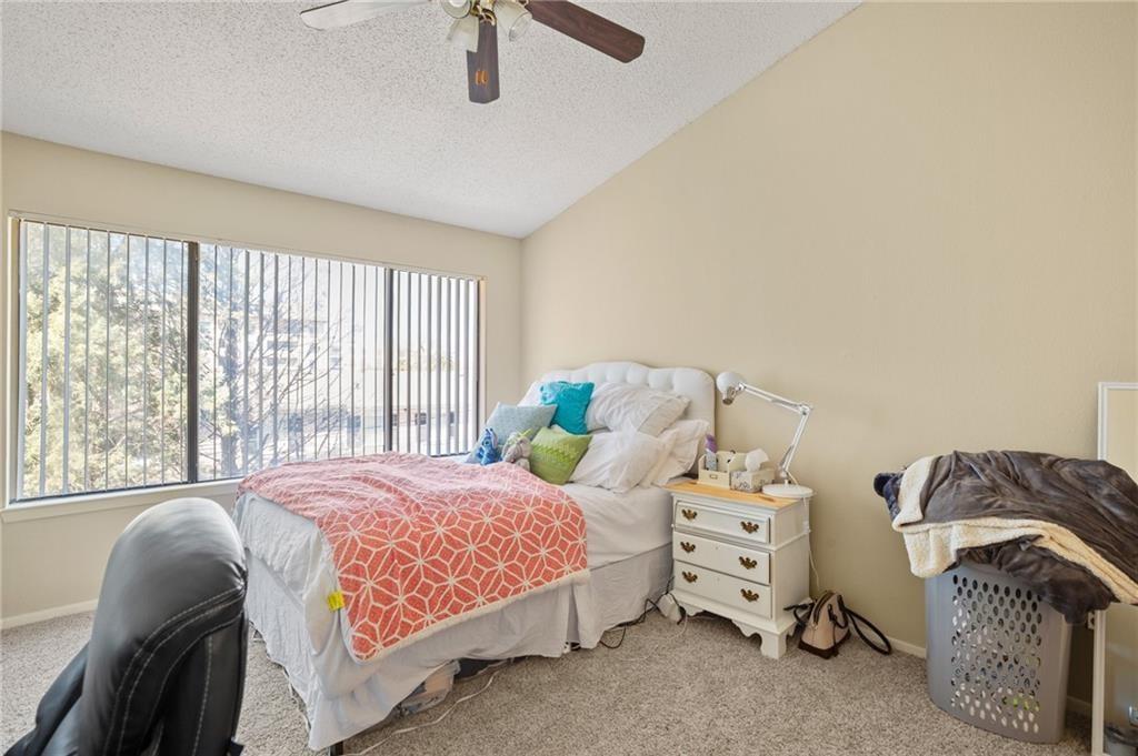 806 West 24th Street, Unit 228 Austin, TX 78705 - Photo 5 of 6 a bedroom with a bed and a chair