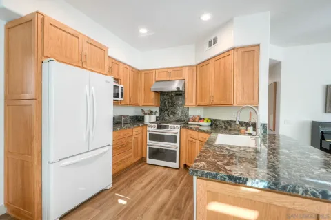 a kitchen with stainless steel appliances granite countertop a refrigerator sink and cabinets