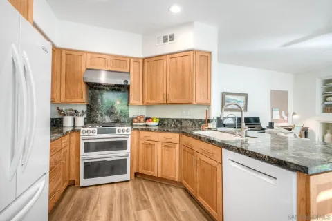 a kitchen with stainless steel appliances granite countertop a stove and a sink